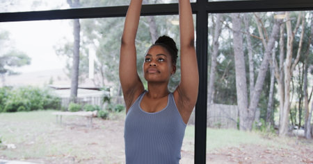 Portrait of african american woman meditating in yoga studio. Wellbeing, fitness, exercise and...