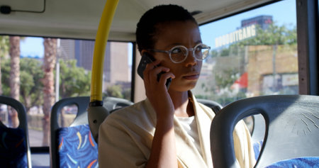 Young female commuter talking on mobile phone while travelling in bus 4k