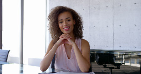 Front view of African American female executive interacting in the office. She is sitting at desk 4kの写真素材