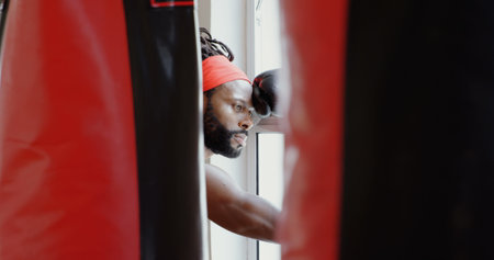 Thoughtful male boxer standing in fitness studioの写真素材