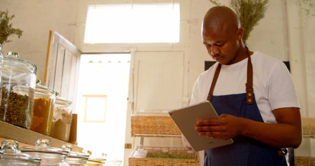 Male stuff checking stocks in supermarket. Male staff using digital tablet 4kの写真素材