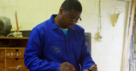 Worker working at table in foundry workshop. Worker using calculator
