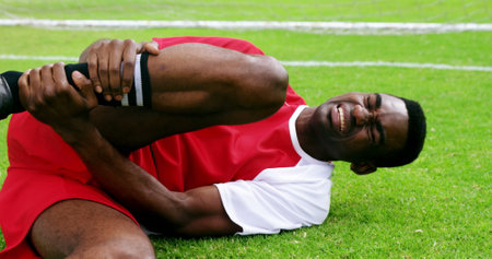 Injured football player lying on grass in the fieldの写真素材