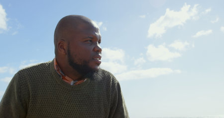 Thoughtful man sitting on bench at promenade. Beautiful sky and cloud in the background 4kの写真素材