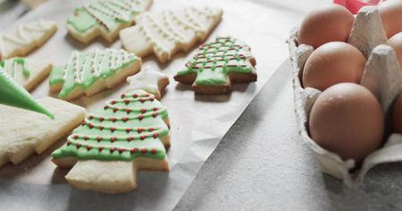Freshly baked Christmas tree cookies decorated with green icing. The scene captures the joy of home baking during the holiday season.の写真素材