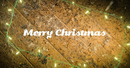 Image of merry christmas text and fairy lights on wooden background. Christmas, tradition and celebration concept digitally generated image.の写真素材