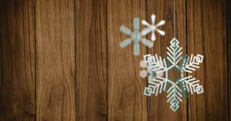 Image of christmas snowflakes decorations over wooden background. Christmas, tradition and celebration concept digitally generated image.の写真素材