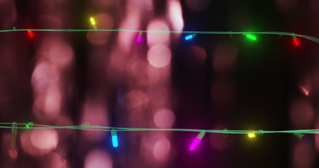 Image of flickering fairy lights over spots of light background. Christmas, tradition and...
