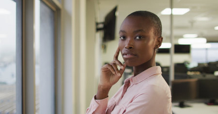 Portrait of african american creative businesswoman touching face, looking at camera. business and office workplace.の写真素材