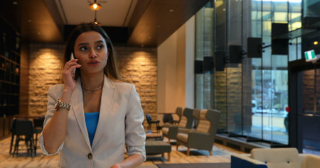 Businesswoman talking on mobile phone in office. Businesswoman holding mobile phone 4kの写真素材