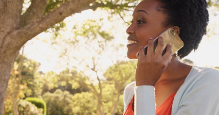 Portrait of woman is talking on the phone in a parkの写真素材