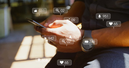 Image of social media icons with numbers over caucasian man using smartphone. Global communication, social media, connections and digital interface concept digitally generated image.の写真素材