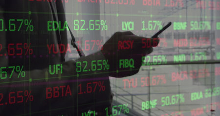 Image of young african american man analyzes stock market data on screens. his focus reflects the...