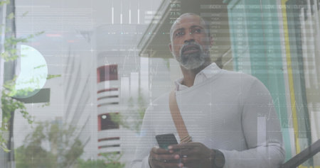Image of diagrams and data processing over african american man using smartphone in city. Business,...