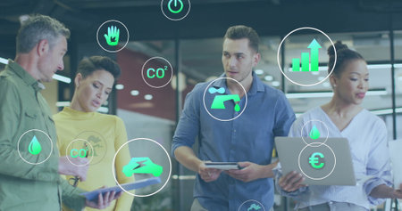 Image of ecology icons over diverse colleagues discussing work in office. Global business and digital interface concept digitally generated image.の写真素材