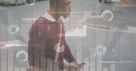 Image of diagrams and data processing over african american man using smartphone in city. Business, technology and digital interface concept digitally generated image.の写真素材