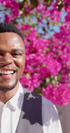 Vertical image of portrait of happy african american man looking at camera and smiling. Wedding day,...