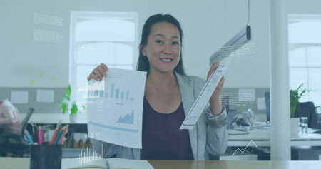 Image of financial data processing over asian businesswoman in office. Global finance, business, connections, computing and data processing concept digitally generated image.の写真素材
