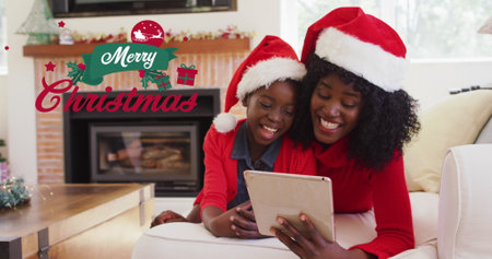 Image of merry christmas text over african american mother and son smiling. Christmas, celebration and digital interface concept digitally generated image.の写真素材