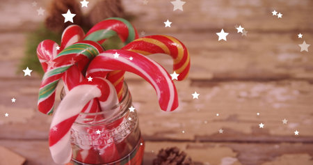 Image of stars over christmas sweets. Christmas, celebration and digital interface concept digitally generated image.の写真素材