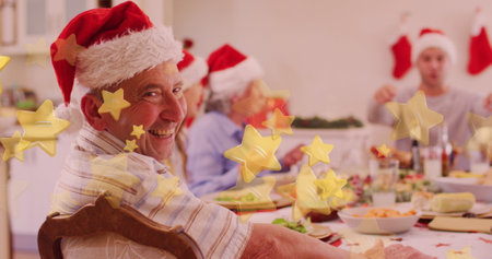 Caucasian family enjoying Christmas dinner, grandfather wearing Santa hat. Grey-haired, he&#39;s smiling, seated at a festive table adorned for occasionの写真素材