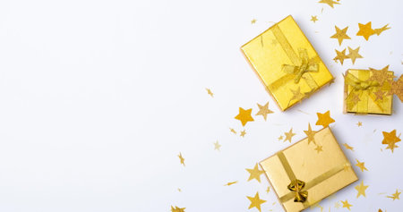 Multiple golden stars floating against christmas of gifts with copy space on white background. christmas festivity and celebration conceptの写真素材