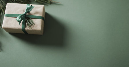 A neatly wrapped gift box lies on a green surface, with copy space. The minimalist presentation suggests a thoughtful gesture for a special occasion.の写真素材