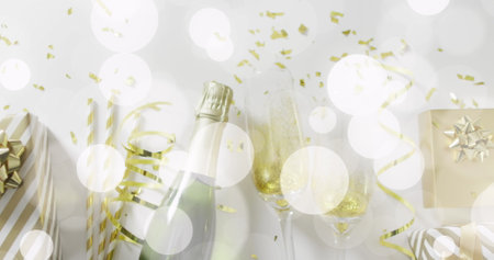 Image of confetti and champagne bottle with glasses. New year's eve, christmas, festivity, celebration and tradition concept digitally generated image.の写真素材