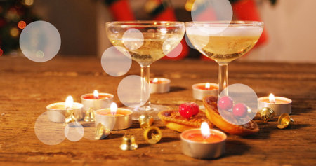 Image of spots at christmas and glasses of champagne. christmas, tradition and celebration concept digitally generated image.の写真素材