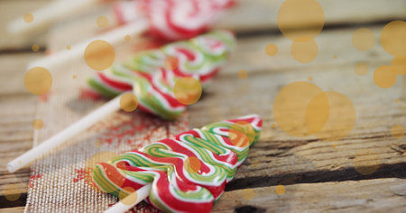 Image of dots moving over christmas tree candies on wooden surface. Christmas, winter, tradition and celebration concept digitally generated image.の写真素材