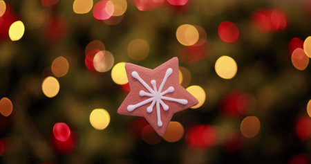 Image of christmas star gingerbread cookie over flickering christmas fairy lights. Christmas,...