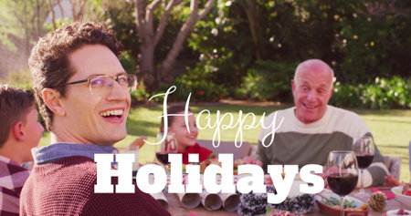 Image of christmas greetings text over caucasian family at christmas table. Christmas, festivity, celebration and tradition concept digitally generated image.の写真素材