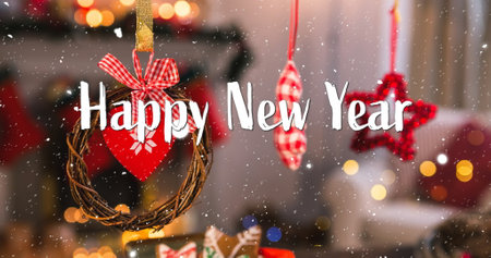 Image of happy new year text over snow falling and christmas decorations. New year, new year&#39;s eve, festivity, celebration and tradition concept digitally generated image.の写真素材