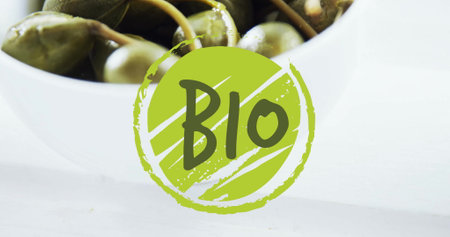 Image of bio text over capers in bowl on table. Diet, healthy lifestyle and food concept digitally generated image.の写真素材