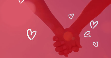 Image of white hearts over caucasian couple holding hands. engagement, marriage, romance and love concept digitally generated image.の写真素材