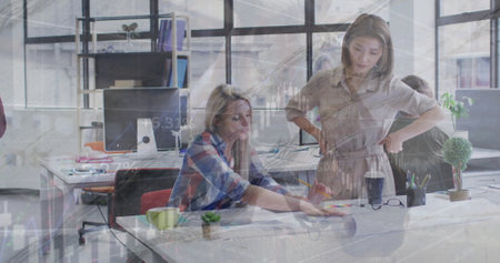 Image of financial data processing over diverse colleagues discussing work in office. Global business, computing, communication and digital interface concept digitally generated image.の写真素材