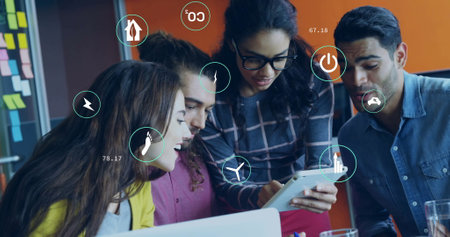 Image of ecology icons and data processing over diverse colleagues discussing work in office. Global business, ecology, computing and digital interface concept digitally generated image.の写真素材