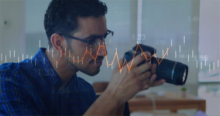 Image of data processing and diagrams over biracial man taking photo in office. Global business, technology and digital interface concept digitally generated image.の写真素材