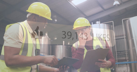 Industrial workers discussing project over social media likes image. Industry, teamwork, collaboration, digital, technology, factoryの写真素材
