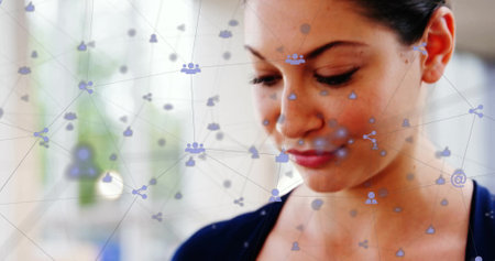 Image of network of connections with digital icons over caucasian businesswoman using smartphone. Global connections, computing and data processing concept digitally generated image.の写真素材