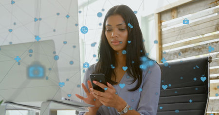 Image of network of connections with digital icons over biracial woman using smartphone. Global connections, computing and data processing concept digitally generated image.の写真素材