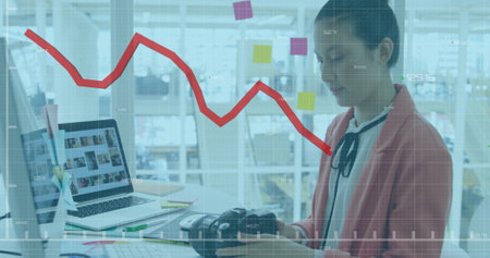 Image of financial data processing over asian businesswoman in office. Global finance, business, connections, computing and data processing concept digitally generated image.の写真素材