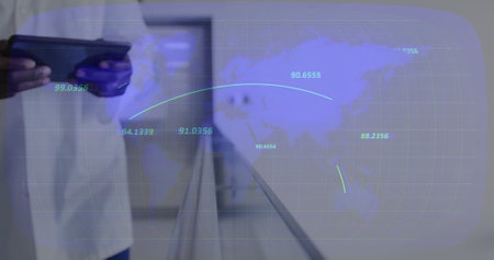 Image of data processing and world map over biracial male doctor using tablet. Technology, medicine...