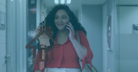 Image of house and key over biracial businesswoman talking on smartphone in office. Business and...