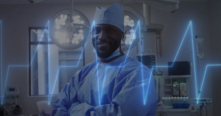 Image of cardiograph over african american male surgeon in operating room. Technology, medicine and digital interface concept digitally generated image.の写真素材