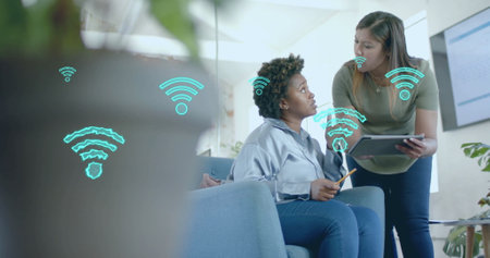 Image of digital wifi icons over diverse business people in office. Global finance, business, connections, computing and data processing concept digitally generated image.の写真素材