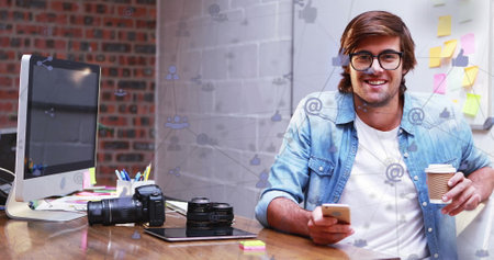 Image of network of connections over caucasian businessman using smartphone. global business, connections, computing and data processing concept digitally generated image.の写真素材