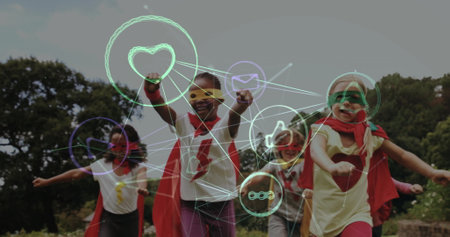 Children in superhero costumes playing outdoors with social media icons image over. Kids, imagination, fun, friendship, joyful, colorfulの写真素材