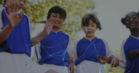 Playing soccer, children in blue uniforms with network connections image over them. teamwork,...