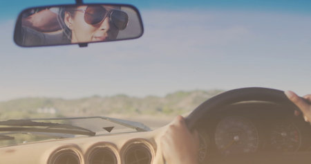 Image of light shade over biracial couple driving car at seaside. Lifestyle, nature and interface...
